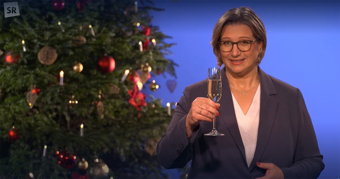 Die saarländische Ministerpräsidentin Anke Rehlinger prostet den Zuschauern bei Ihrer Neujahrsansprache zu. © Screenshot der TV-Ansprache im Saarländischen Rundfunk