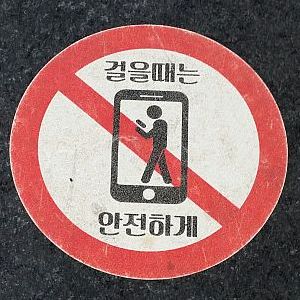 Hinweise auf südkoreanischen Bürgersteigen holen den Smartphone-Nutzer zurück in die reale Welt. (c) Georg Milde
